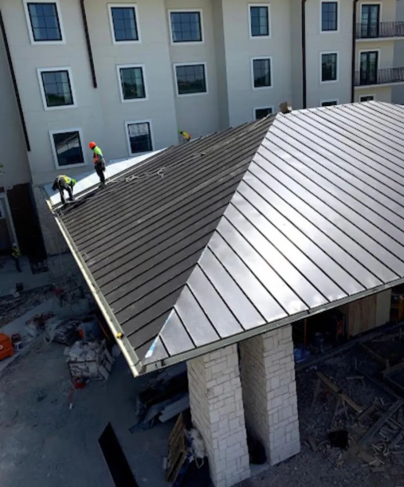 Crew installing standing seam metal roof panels on a commercial project in North Ridgeville